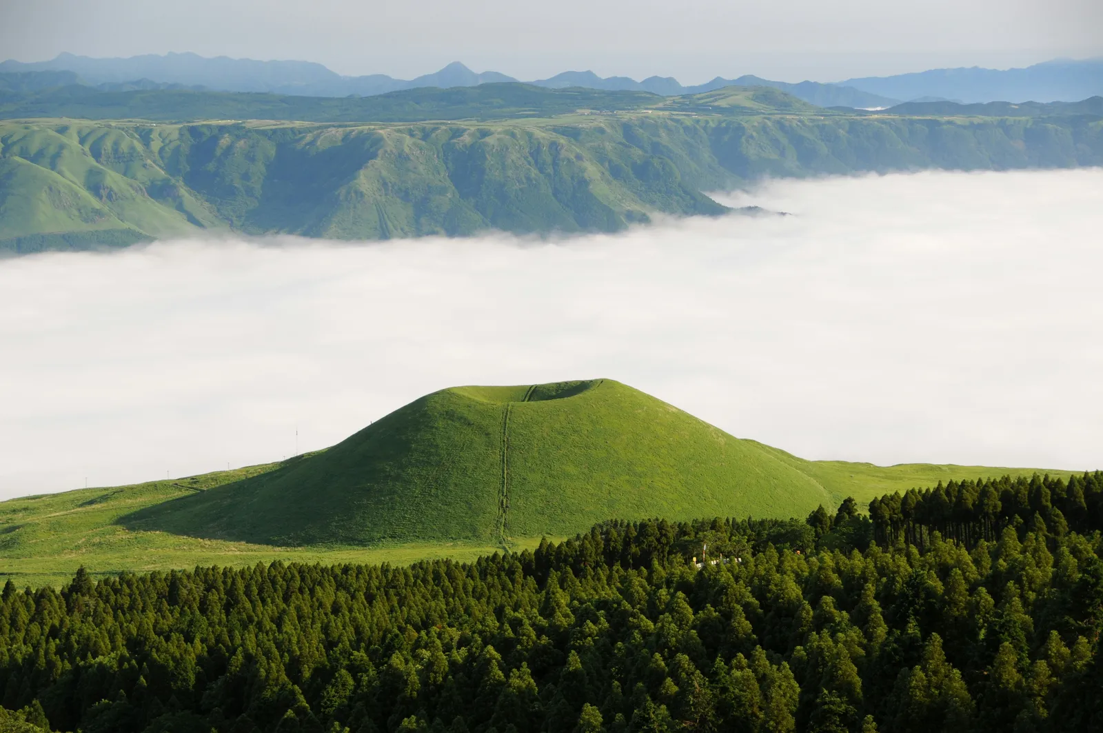 雲海の上に広がる阿蘇の緑の山々と米塚
